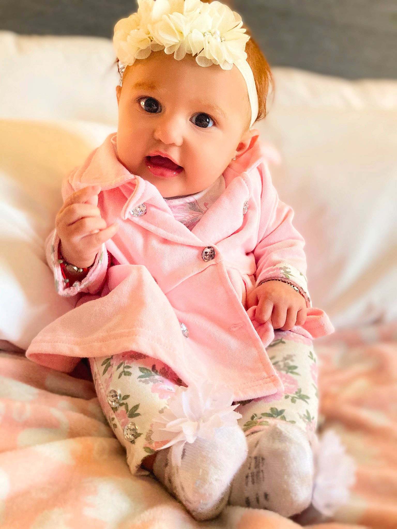 Norma is registered to the contest to win money with this photo: arm, baby, baby_toddler_clothing, cheek, clothing, collar, comfort, dress, eye, face, finger, hand, head, headwear, lip, neck, outerwear, person, pink, skin