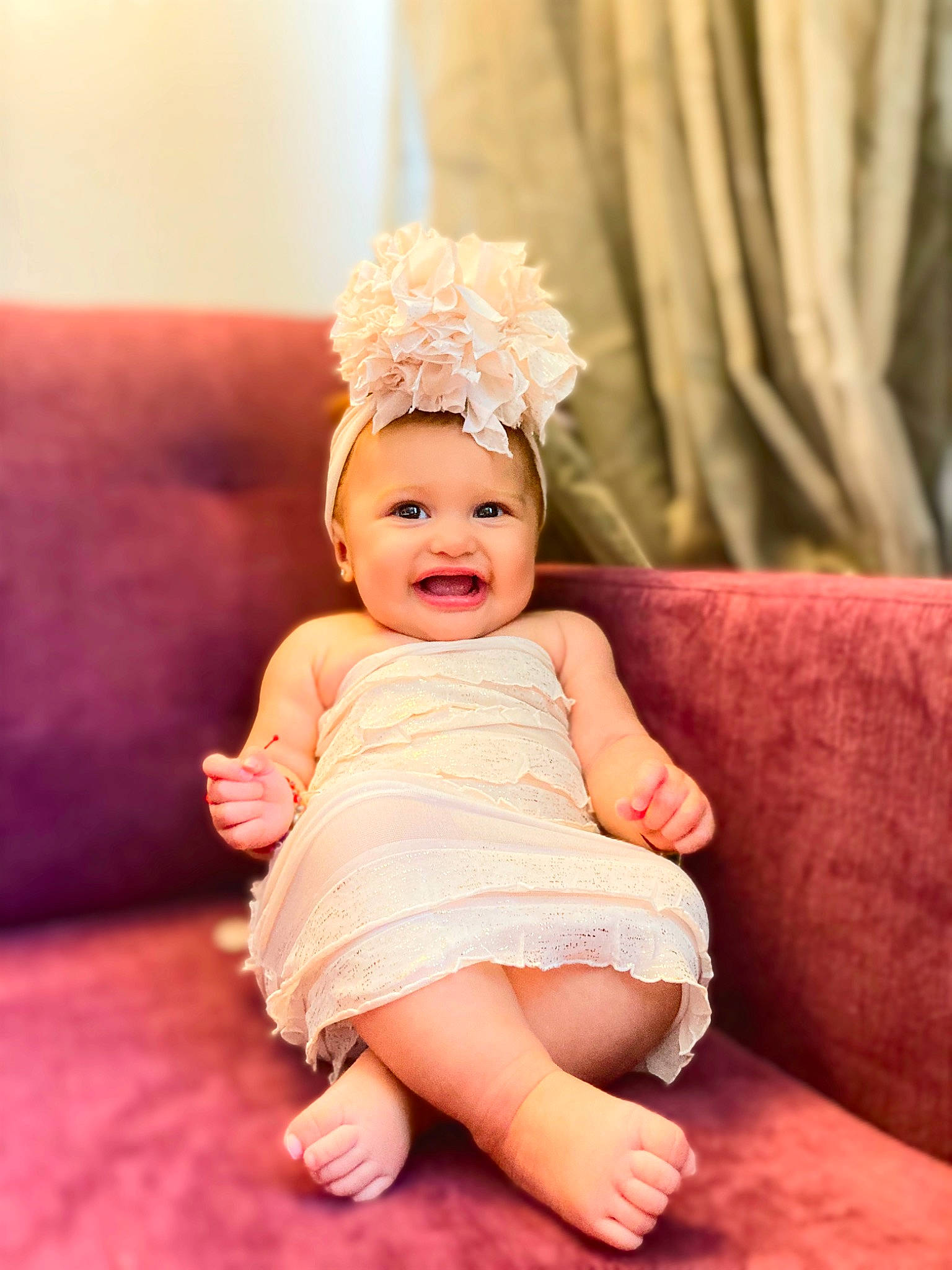 Norma is registered to the contest to win money with this photo: baby, baby_toddler_clothing, child, couch, dress, eye, face, flash_photography, happy, hat, head, headband, headpiece, headwear, human_body, iris, person, pink, skin, smile