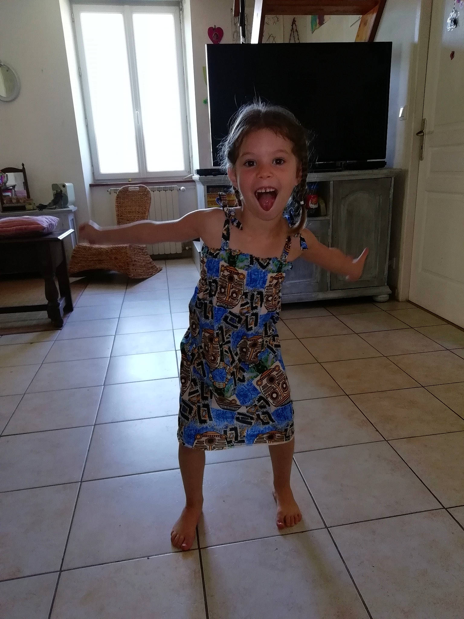Angoon participe au concours pour gagner de l'argent avec cette photo : child, dress, floor, flooring, joy, person, room, shoulder, smile, standing, tile, toddler, vacation