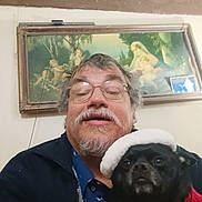 Dasiey joined the competition — help win amazing prizes! man, glasses, beard, dog, black_dog, hat, red_sweater, indoor, portrait, painting, frame, wall, smile, pet, animal, face, eyewear, mustache, coat, casual