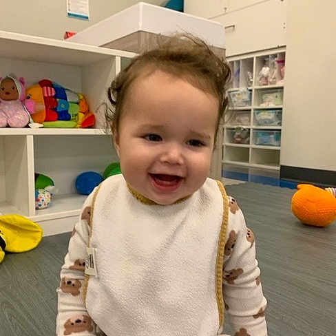 Rayna joined the competition — help win amazing prizes! toddler, child, smiling, baby, pajamas, bib, indoor, playroom, floor, toy, colorful, cabinet, sitting, happy, face, clothing, babytoy, furniture, childcare, room