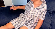 Kingston is registered to the contest to win money with this photo: child, toddler, couch, remote_control, striped_clothing, indoor, furniture, person, relaxing, home, young_child, seated, living_room, casual, expressionless, short_sleeves, shorts, modern, comfort, technology