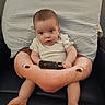 baby, infant, remote_control, plush_cushion, flamingo_cushion, striped_pillow, chair, seated, indoor, clothing, short_sleeves, curious, looking_at_camera, person, child, skin, legs, feet, face, expression