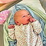 Ocean is registered to the contest to win money with this photo: baby, newborn, infant, blanket, knitted, onesie, floral, pastel, soft, sleepwear, cute, small, child, person, skin, hand, face, lying_down, indoors, cozy