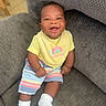 Trinity is registered to the contest to win money with this photo: armchair, baby, baby_boy, child, clothing, cozy, cute, face, furniture, happy, home, indoor, infant, person, portrait, sitting, smiling, striped_shorts, white_socks, yellow_bib