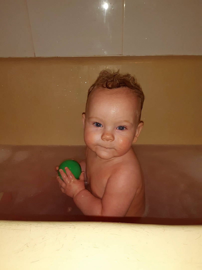 Coen is registered to the contest to win money with this photo: baby, baby_bathing, bathing, bathtub, cheek, child, face, finger, forehead, hand, head, mouth, person, plumbing_fixture, room, skin, thumb, toddler