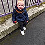 Charly participe au concours pour gagner de l'argent avec cette photo : child, toddler, smiling, blonde_hair, blue_jacket, scarf, toy_cars, concrete, purple_railing, sidewalk, outdoor, casual_clothing, white_shoes, happy, person, street, daylight, playful, young_child, sitting