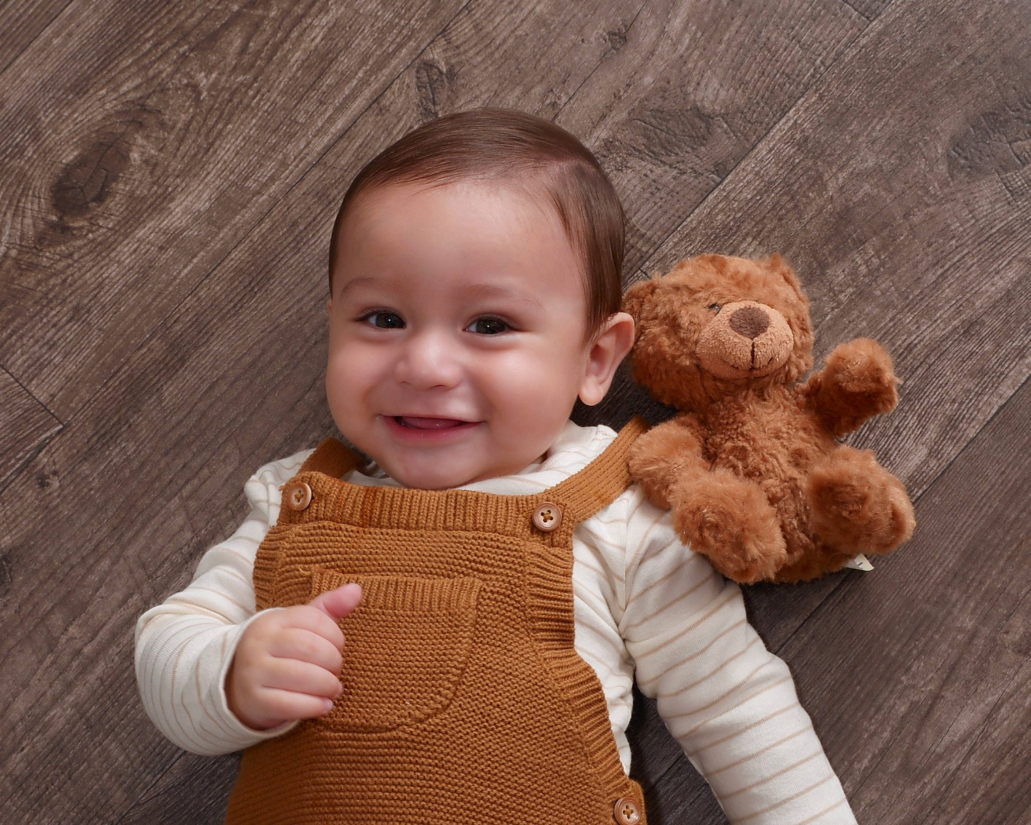 Grayson joined the competition — help win amazing prizes! baby, baby_toddler_clothing, brown, cheek, face, finger, gesture, hand, happy, human_body, joy, nose, outerwear, person, skin, sleeve, smile, stuffed_toy, thumb, toddler