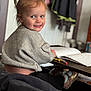 Haisley joined the competition — help win amazing prizes! toddler, child, smiling, pony_tail, gray_sweater, coloring_book, crayons, table, shoes, socks, indoor, home, furniture, person, portrait, happy, playful, young_child, cozy, casual