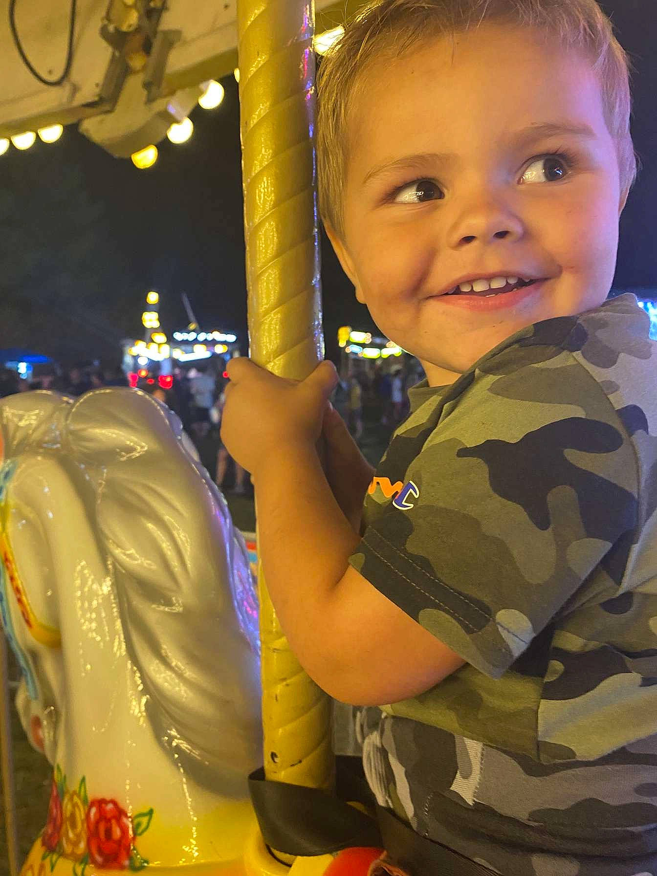 Leland is registered to the contest to win money with this photo: arm, baby, child, event, facial_expression, finger, fun, gesture, hairstyle, happy, joy, leisure, military_camouflage, military_person, pattern, person, recreation, smile, standing, thumb