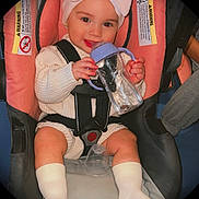 Khloe is registered to the contest to win money with this photo: baby, child, car_seat, pink, headband, bow, sippy_cup, smile, white_socks, cream_sweater, infant, cute, happy, indoors, seatbelt, portrait, person, young_child, baby_girl, cozy