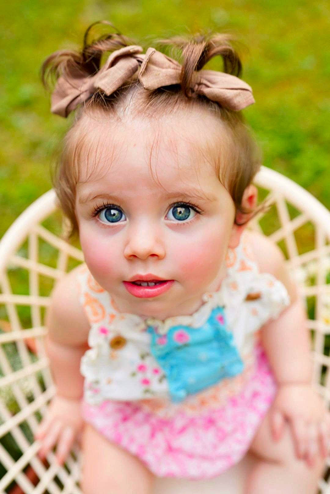 Lainey is registered to the contest to win money with this photo: arm, baby, baby_toddler_clothing, cheek, dress, eyelash, face, fawn, grass, happy, headpiece, human_body, iris, jewellery, lip, person, pink, skin, sleeve, toddler