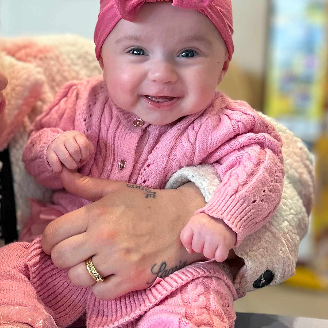 Amyrah is registered to the contest to win money with this photo: accessories, baby, bodypart, cap, clothing, couch, face, finger, furniture, hand, happy, hat, head, jewelry, knitwear, person, photography, portrait, smile, sweater