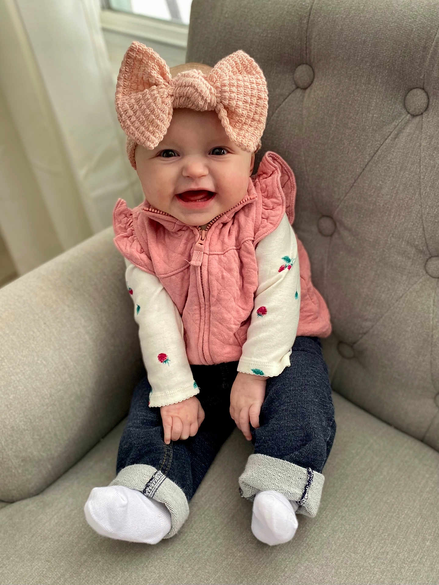 Lucia joined the competition — help win amazing prizes! baby, child, smiling, pink_bow, headband, pink_vest, white_shirt, jeans, white_socks, armchair, indoor, cute, happy, portrait, infant, seated, toddler, buttoned_vest, fabric, cozy