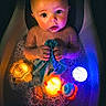 baby, bathtub, bathwater, bubbles, child, toy, bath_toy, glowing, blue, orange, yellow, water, skin, cloth, cute, indoors, head, face, sitting, expression
