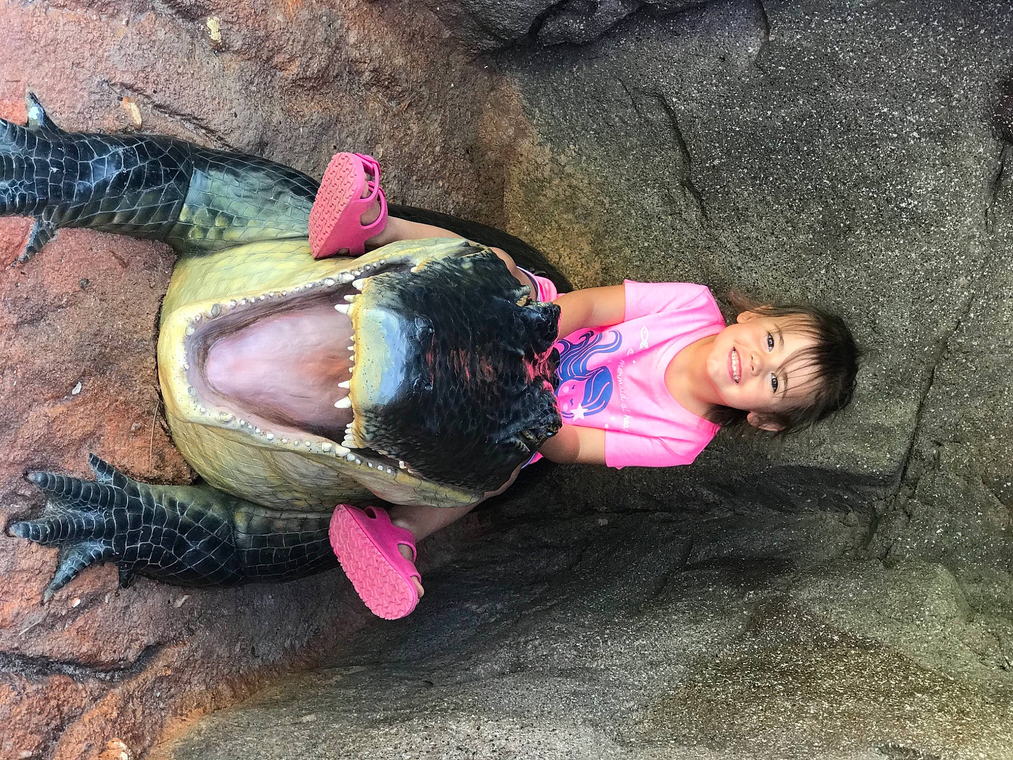 Layla is registered to the contest to win money with this photo: asphalt, fun, grass, hand, happy, human_body, joy, leg, leisure, magenta, organism, person, play, recreation, reptile, sand, sitting, soil, sunglasses, tail