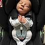 baby, sleeping, car_seat, infant, white_clothing, child, seatbelt, straps, peaceful, hands, face, head, portrait, indoor, black, soft_lighting, newborn, cozy, closeup, resting