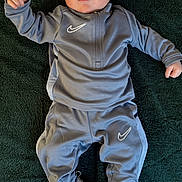 Casey joined the competition — help win amazing prizes! baby, blanket, casual, child, clothing, cute, expression, face, footwear, green, head, indoor, infant, lying_down, nike, person, portrait, sneakers, sportswear, tracksuit