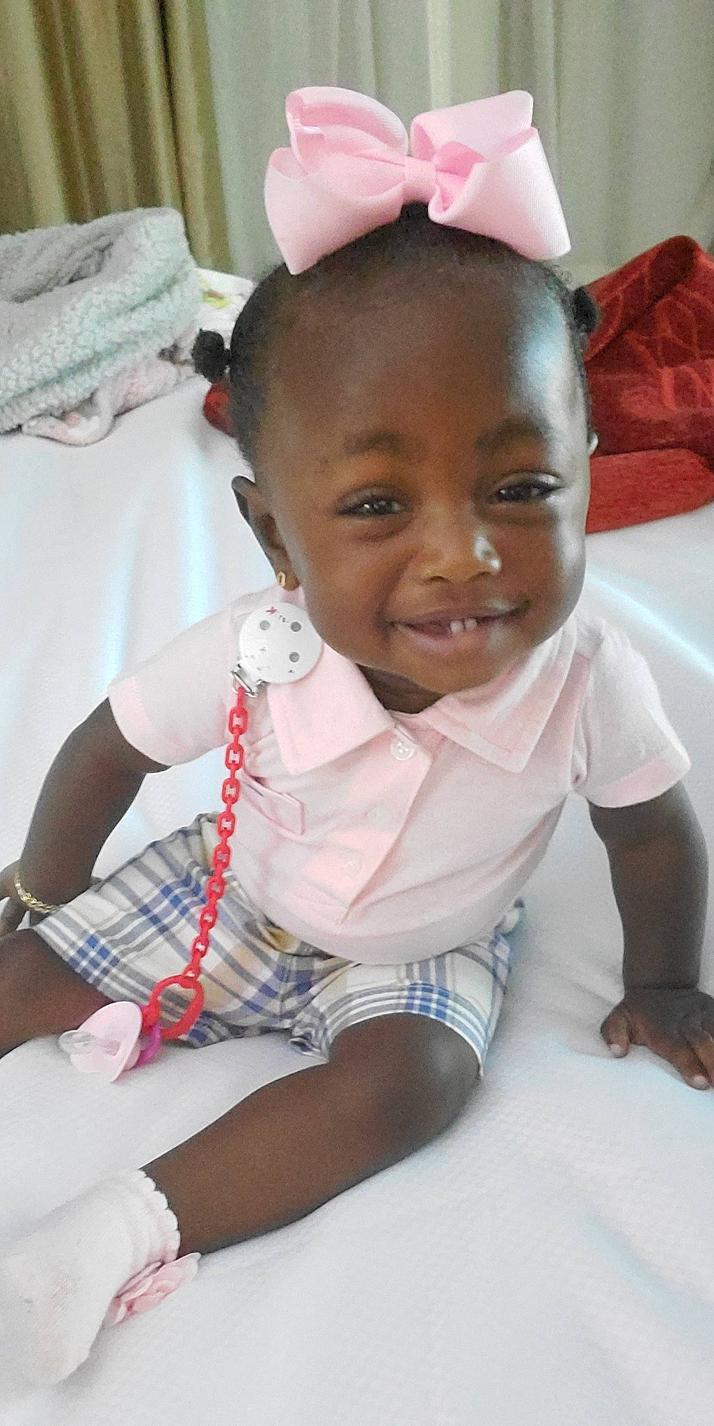 Queen is registered to the contest to win money with this photo: arm, baby, baby_toddler_clothing, cheek, child, comfort, event, eyelash, happy, iris, jewellery, joy, person, pink, sitting, skin, smile, tartan, textile, thigh