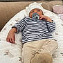 baby, newborn, pacifier, hat, striped_shirt, cushion, soft_fabric, relaxed, lying_down, indoor, cute, infant, child, comfort, cozy, small_hand, clothing, headwear, patterned, resting