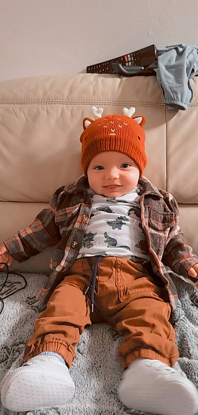 Raphaël a rejoint le concours — aidez-le/la à gagner de superbes lots ! baby, baby_products, baby_safety, baby_toddler_clothing, beanie, cap, child, comfort, fashion_accessory, flooring, fur, headgear, headwear, knit_cap, pattern, person, personal_protective_equipment, room, sitting, sleeve