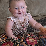 Karley joined the competition — help win amazing prizes! baby, child, smiling, couch, blanket, toy, indoor, face, clothing, happy, person, seated, pattern, fabric, cute, infant, portrait, home, comfort, playful