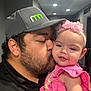 Eliza joined the competition — help win amazing prizes! man, baby, kiss, pink_clothing, headband, indoor, facial_hair, cap, child, love, affection, portrait, family, smile, person, cute, closeup, happy, baby_girl, tenderness