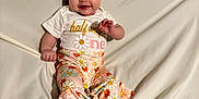 Eliza joined the competition — help win amazing prizes! baby, infant, crown, half_birthday, smiling, floral_pants, white_blanket, cute, celebration, lying_down, child, happy, portrait, clothing, footwear, headwear, indoors, person, infant_fashion, milestone