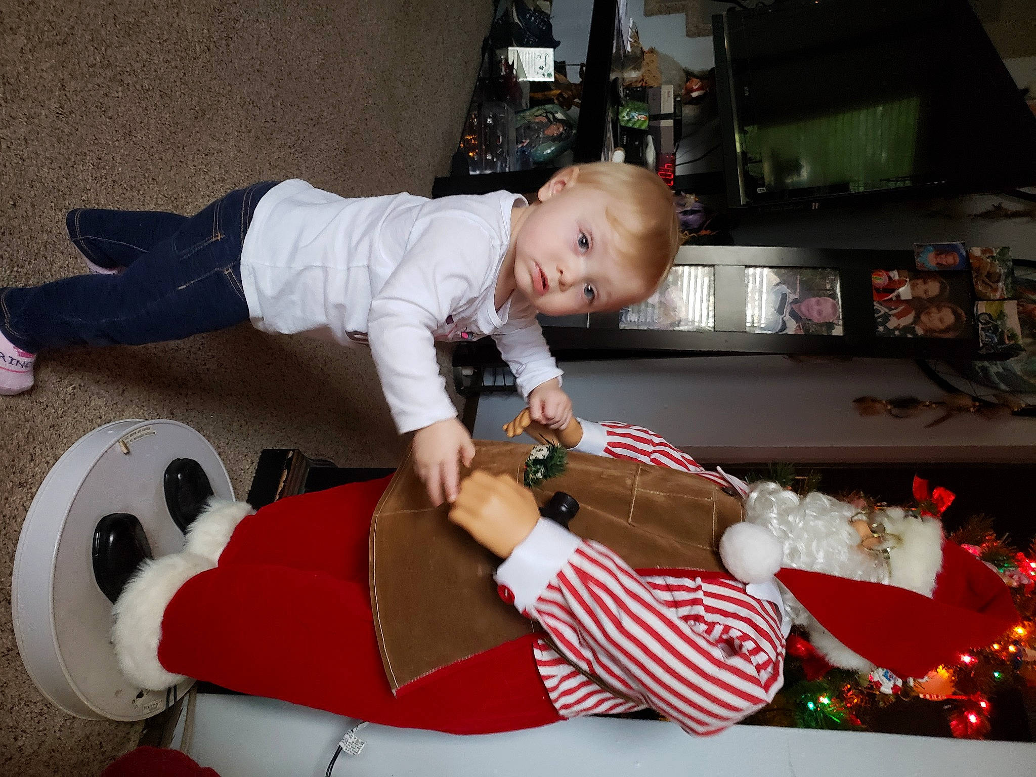 Demi is registered to the contest to win money with this photo: ankle, baby, baby_toddler_clothing, christmas, christmas_decoration, christmas_eve, foot, holiday, human, human_body, joy, lap, person, santa_claus, shelf, shoe, sock, stuffed_toy, television, toddler