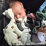 baby, sleeping, pacifier, plush_toy, giraffe, soft_toy, infant, child, cozy, car_seat, clothing, cute, hand, comfort, dark_background, peaceful, toy, childhood, rest, cuddly