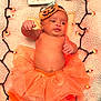 Calliope is registered to the contest to win money with this photo: baby, infant, orange_tutu, pumpkin_headband, blanket, fairy_lights, pumpkin, sign, autumn, fall, holiday, cute, festive, soft_texture, decor, glowing_lights, costume, child, portrait, celebration