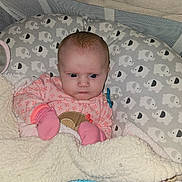 Willow-Ann is registered to the contest to win money with this photo: baby, infant, child, portrait, sitting, pink_clothing, pacifier, blanket, crib, baby_nest, elephant_pattern, wide_eyed, serious_expression, indoor, cozy, textile, head, face, photography, nursery