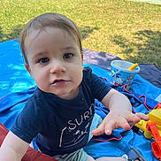 Elio a rejoint le concours — aidez-le/la à gagner de superbes lots ! child, toddler, outdoor, grass, blanket, toy, bucket, shoes, shorts, tshirt, hand, face, eyes, hair, park, sunlight, nature, playing, summer, cute