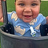 toddler, child, swing, smiling, blue_shirt, polar_bear_print, pacifier_clip, outdoor, playground, green_grass, happy, face, hand, baby, person, cute, closeup, joyful, cheeks, holding
