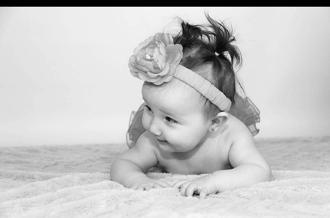 Emy a rejoint le concours — aidez-le/la à gagner de superbes lots ! baby, baby_toddler_clothing, child, ear, eye, flash_photography, flower, grass, hair_accessory, happy, headgear, headpiece, iris, monochrome, monochrome_photography, person, petal, plant, skin, smile