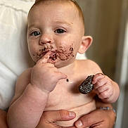 Alaric is registered to the contest to win money with this photo: baby, child, chocolate, closeup, cookie, curious, cute, expression, face, fingers, food, hands, holding, indoor, mess, messy, person, portrait, skin, snack