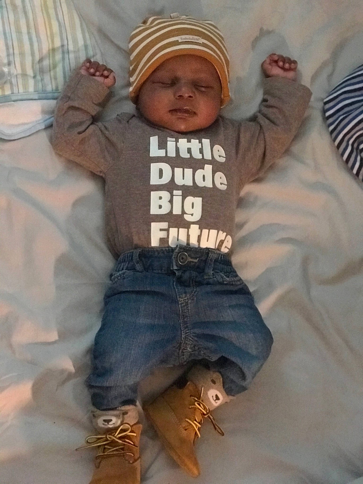 Shai is registered to the contest to win money with this photo: arm, baby, baby_toddler_clothing, cap, cool, denim, face, finger, gesture, hand, happy, hat, headwear, human_body, jeans, organ, person, sleeve, t_shirt, textile