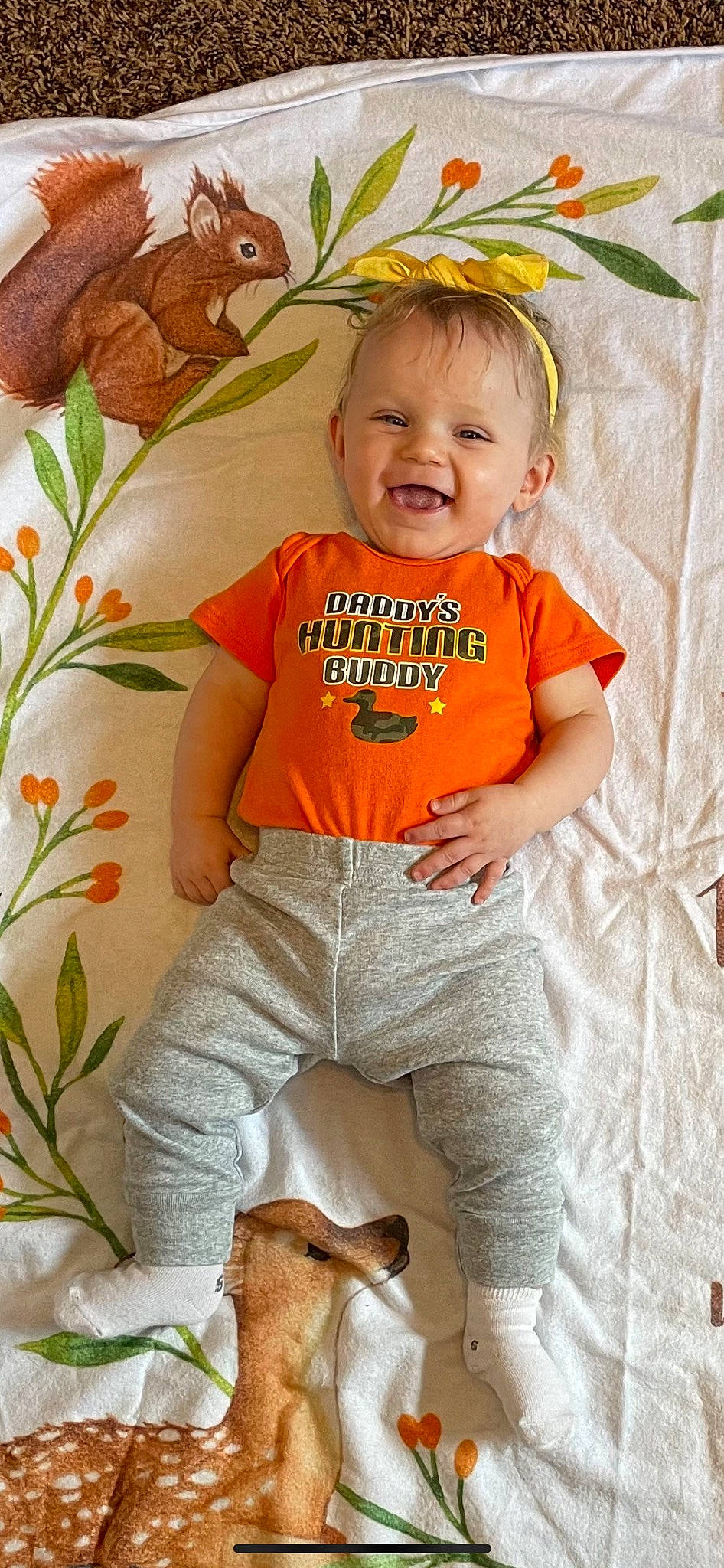 Kamryn joined the competition — help win amazing prizes! baby_toddler_clothing, child, eye, face, facial_expression, grass, happy, head, leaf, orange, organ, people_in_nature, person, plant, product, skin, sleeve, smile, t_shirt, textile