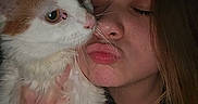 Demi is registered to the contest to win money with this photo: cat, woman, person, pet, portrait, close_up, orange_and_white, fur, whiskers, nose, face, eyes, closed_eyes, cuddling, holding, indoor, dim_lighting, selfie, affection, human_animal_bond
