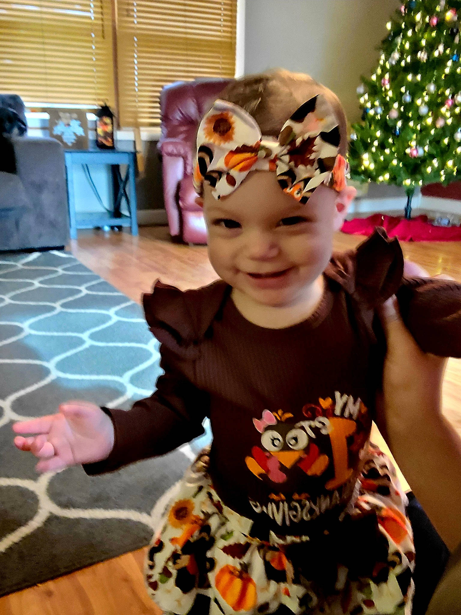 Lilly is registered to the contest to win money with this photo: baby_toddler_clothing, cap, child, christmas_tree, costume, event, eyewear, fashion_accessory, flooring, fun, happy, headband, headpiece, headwear, holiday, joy, leisure, person, personal_protective_equipment, smile