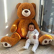 Kayden a rejoint le concours — aidez-le/la à gagner de superbes lots ! baby, teddy_bear, toy, floor, window, reflection, smile, child, indoor, plush, wooden_floor, light, shadow, white_clothing, striped_pants, cute, happy, sitting, cozy, corner