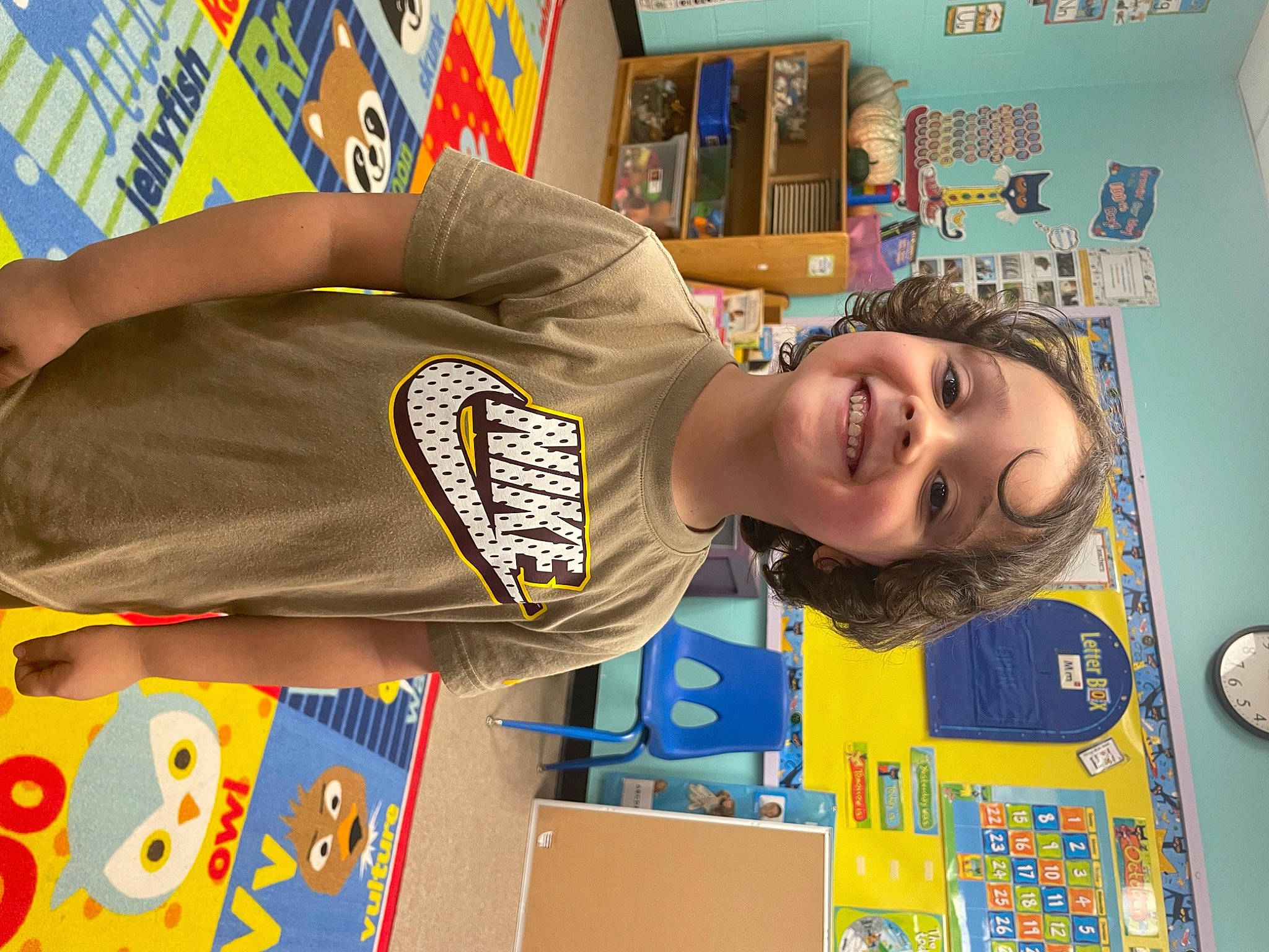 Chandler is registered to the contest to win money with this photo: art, bookcase, child, fun, happy, joy, kindergarten, laugh, leisure, person, play, room, shelf, shelving, sleeve, smile, sportswear, t_shirt, toddler, visual_arts