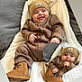 baby, infant, smiling, brown_clothing, beanie, boots, blanket, quilted, bracelet, cute, portrait, indoor, child, happy, warm_clothing, footwear, face, person, cozy, apparel