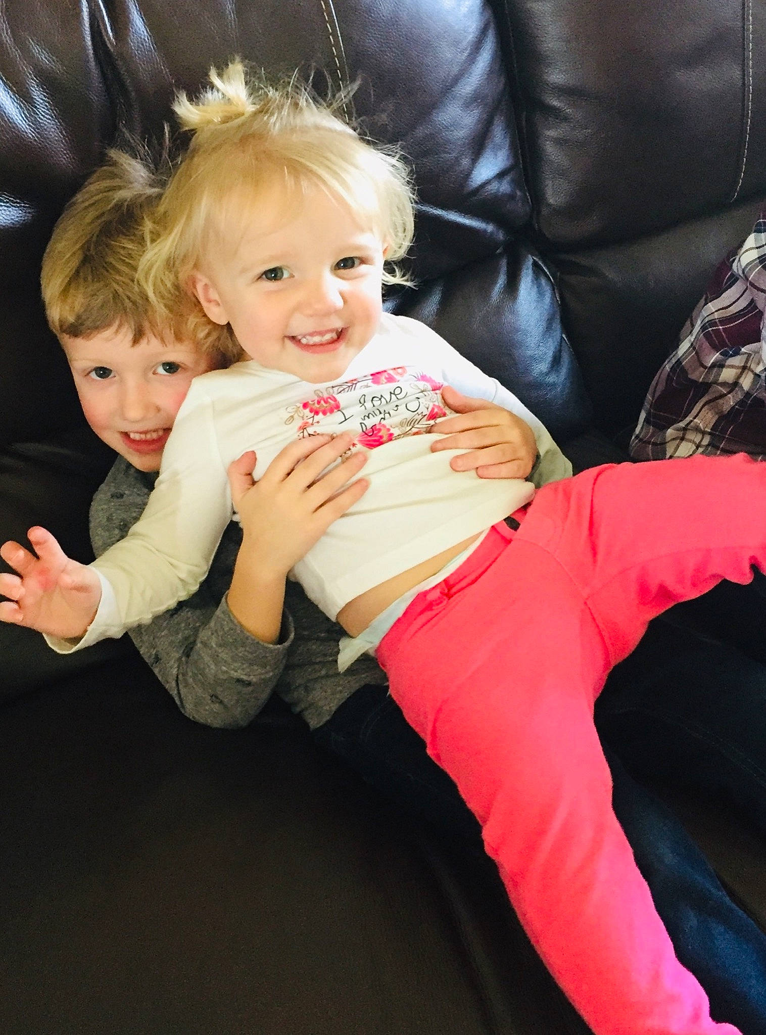 Aniston is registered to the contest to win money with this photo: baby, child, child_model, daughter, finger, fun, joy, leg, person, pink, play, sibling, sitting, smile, toddler