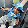 Alisson Nzambi participe au concours pour gagner de l'argent avec cette photo : baby, blue_clothing, bucket_hat, casual, chair, child, comfortable, curious_expression, cute, fashion, gray_pants, indoor, infant, nike_logo, person, portrait, shadow, sitting, sunlight, white_shoes