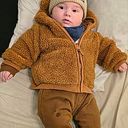 Brayan-Adam a rejoint le concours — aidez-le/la à gagner de superbes lots ! baby, bed, brown_jacket, child, cute, face, hat, indoor, infant, lying_down, mickey_mouse_hat, pants, person, pillow, pom_poms, portrait, sleepwear, warm_clothing, white_socks, young_child