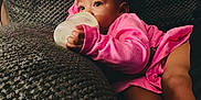 Samari joined the competition — help win amazing prizes! baby, bottle, pink_clothing, couch, texture, infant, milk, hand, face, eyes, socks, relaxing, indoor, person, comfort, child, young, resting, soft, casual