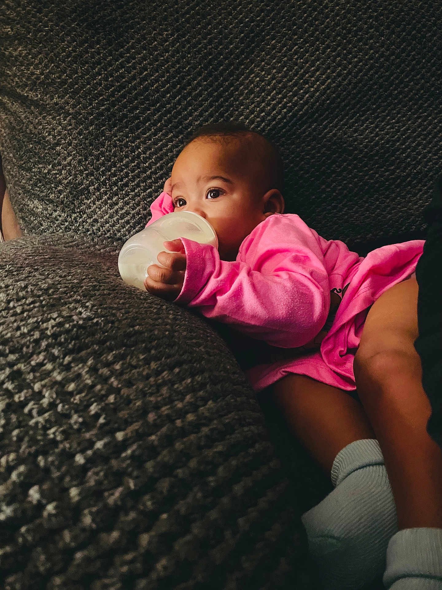 Samari joined the competition — help win amazing prizes! baby, bottle, pink_clothing, couch, texture, infant, milk, hand, face, eyes, socks, relaxing, indoor, person, comfort, child, young, resting, soft, casual