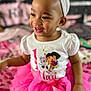 Samari joined the competition — help win amazing prizes! toddler, smiling, headband, pink_tutu, white_shirt, dora_the_explorer, child, happy, indoors, portrait, cute, clothing, baby, person, fun, colorful, sitting, playful, face, young_child