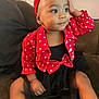 Samari joined the competition — help win amazing prizes! child, toddler, red_headband, red_jacket, heart_pattern, black_dress, sitting, couch, indoor, curious_expression, person, face, cute, baby, hand_on_head, clothing, portrait, young_child, casual, home